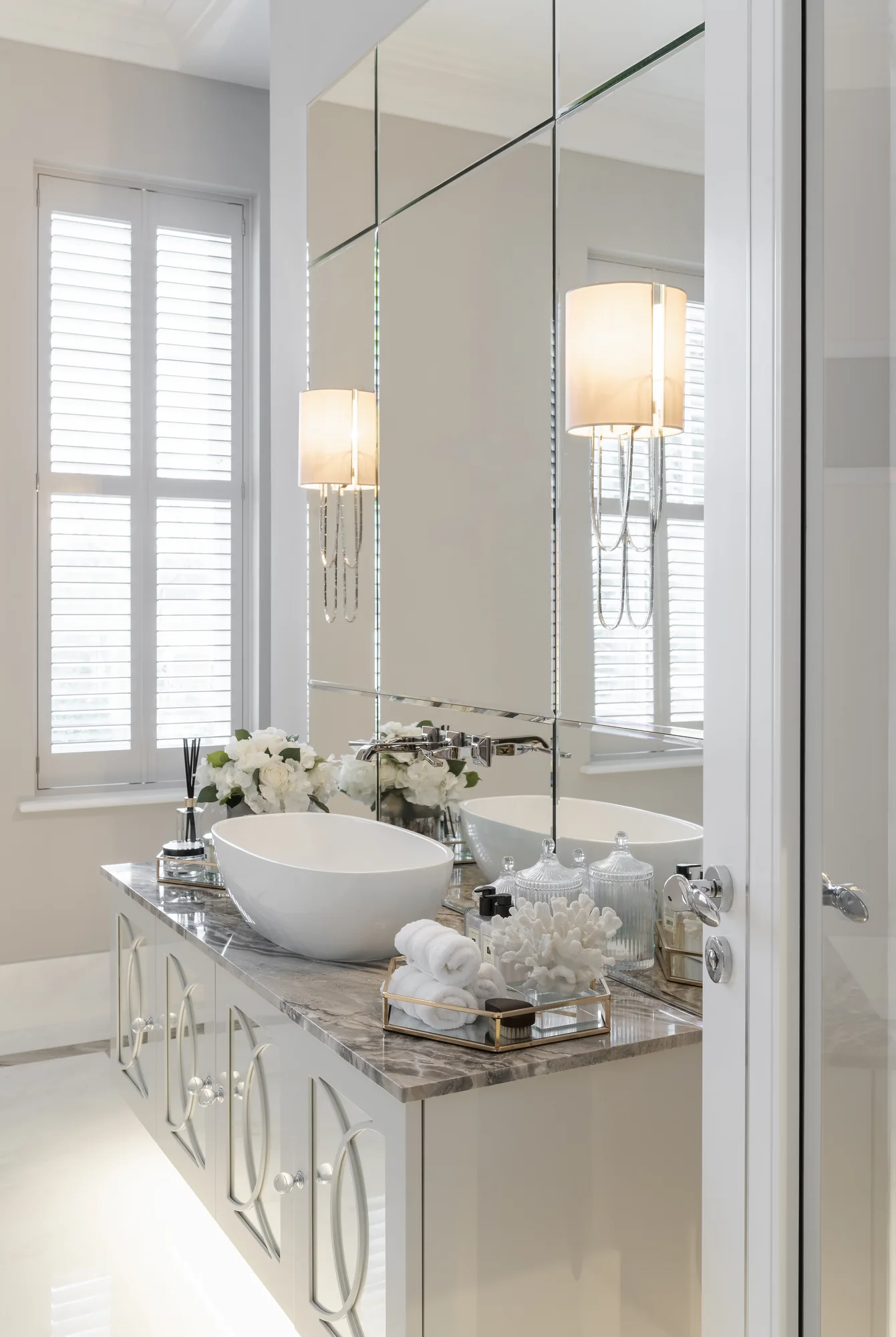 Angled view of the pale vanity cabinetry beneath the veined counter