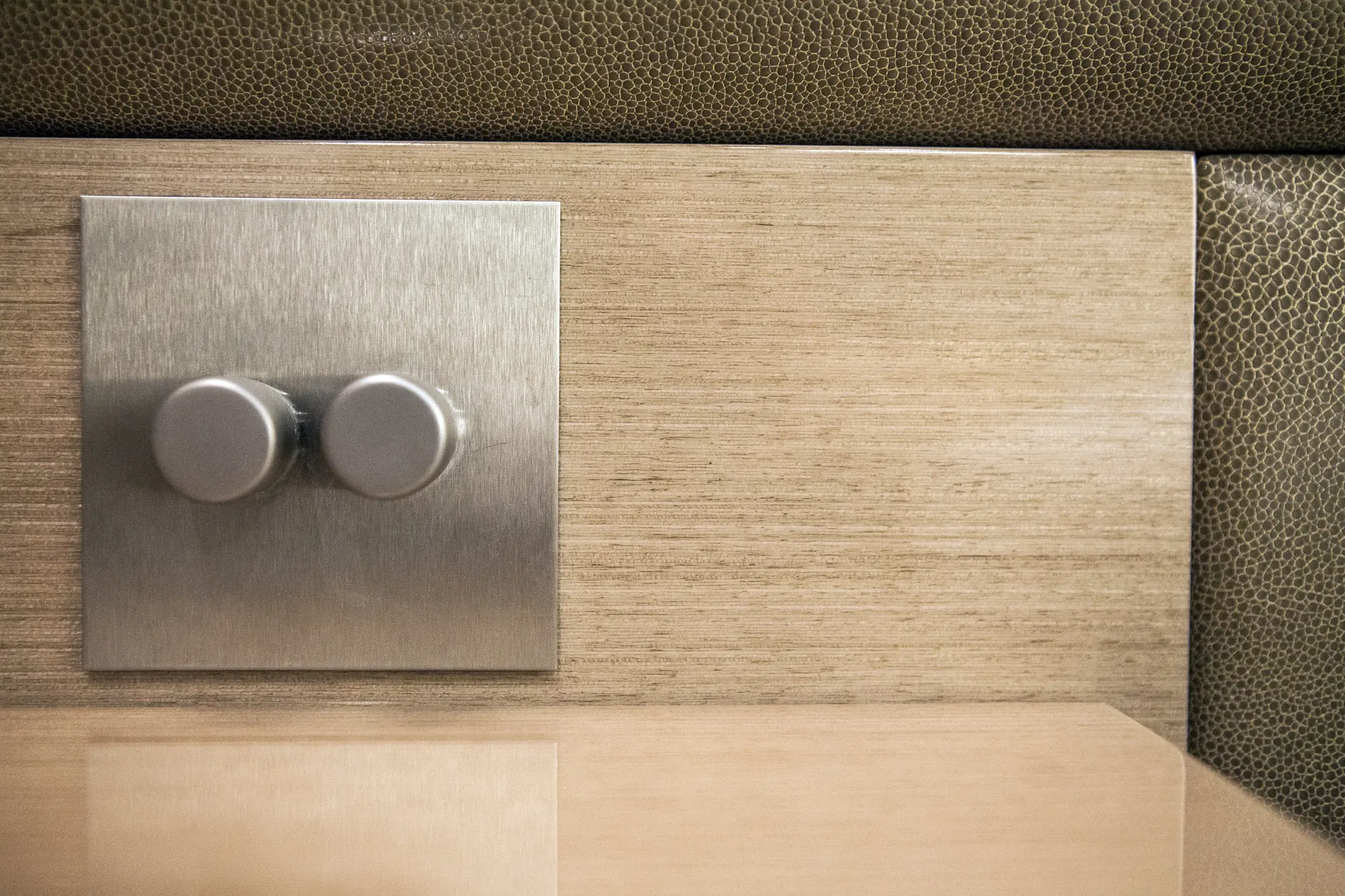 Bedside dimmer switches mounted on a textured inset panel