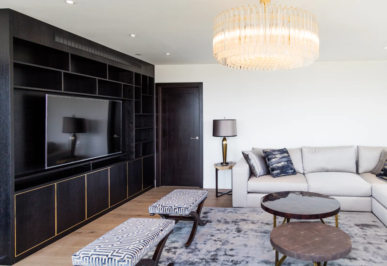 Room view of dark fitted TV wall with open shelving and lower storage