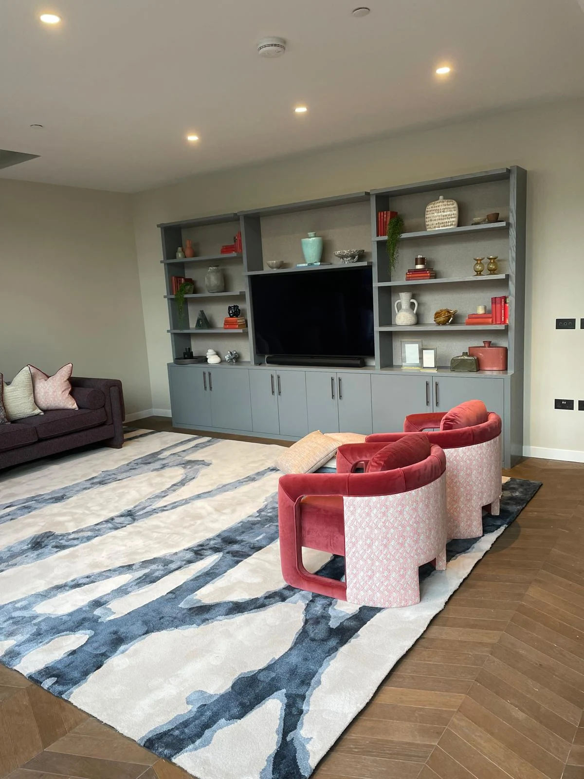 Wide room view of the blue-grey display wall and seating area.
