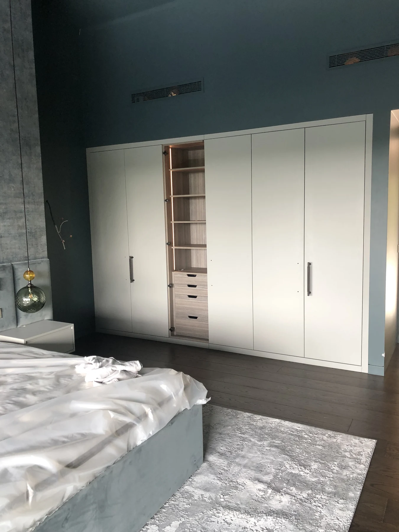 White wardrobe fronts and an open centre compartment in the contemporary fitted bedroom.