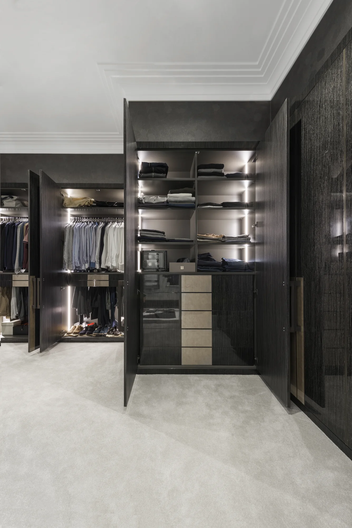 Dark walk-in wardrobe showing open hanging and shelf storage
