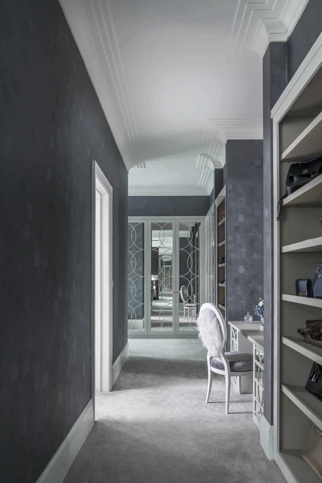 View along the passage towards mirrored wardrobe doors and shoe storage