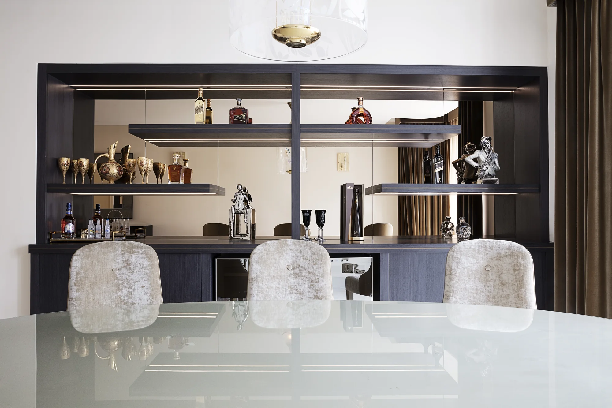 Full dining-wall view of dark display cabinetry behind the table