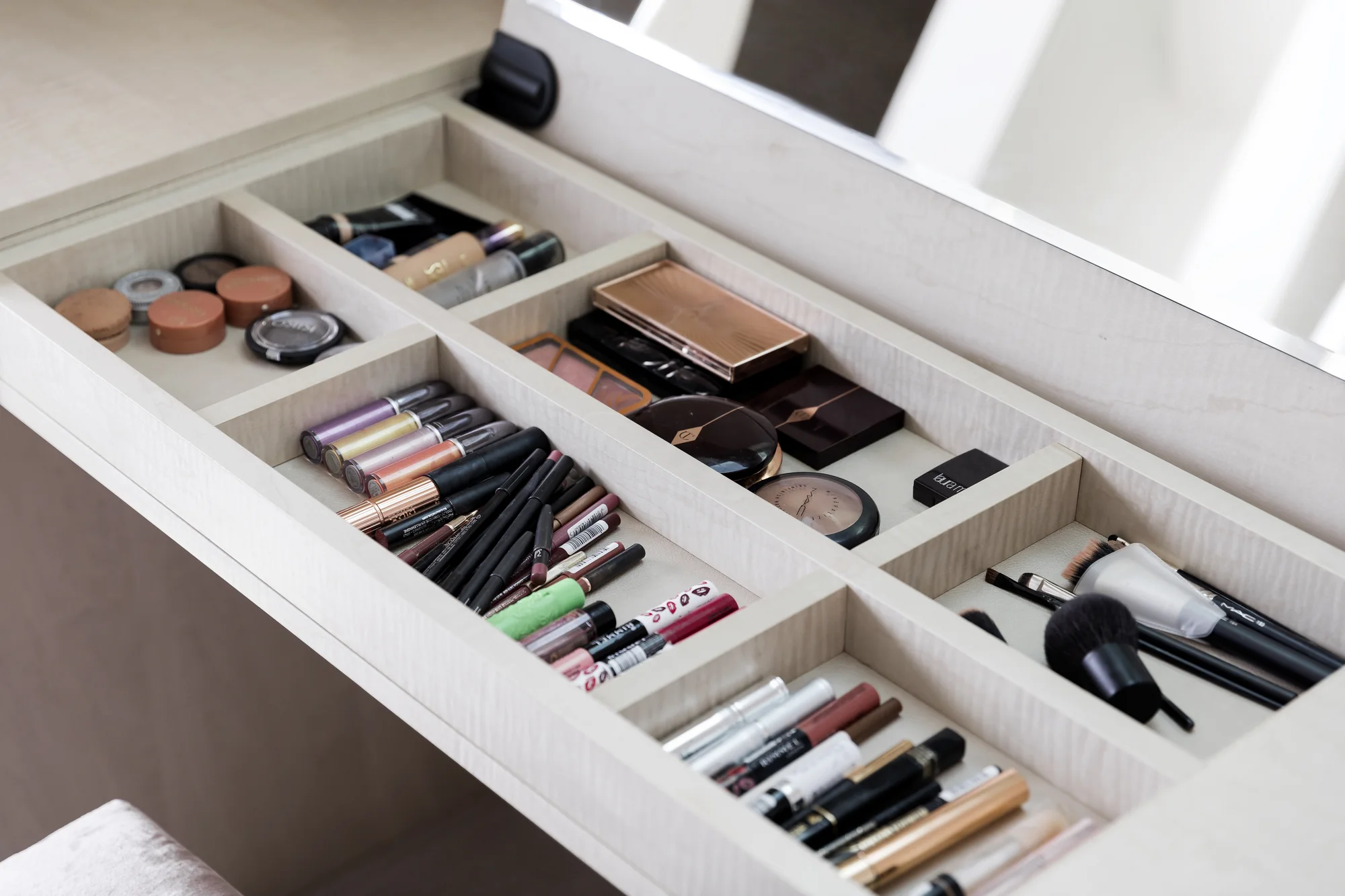 Divided dressing-table tray containing cosmetics and brushes