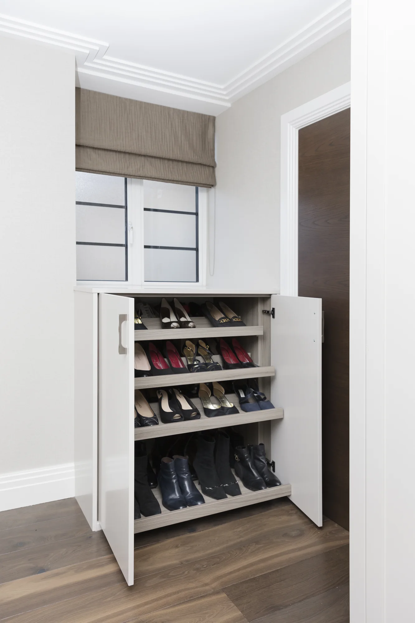 Open shoe cupboard beneath the window
