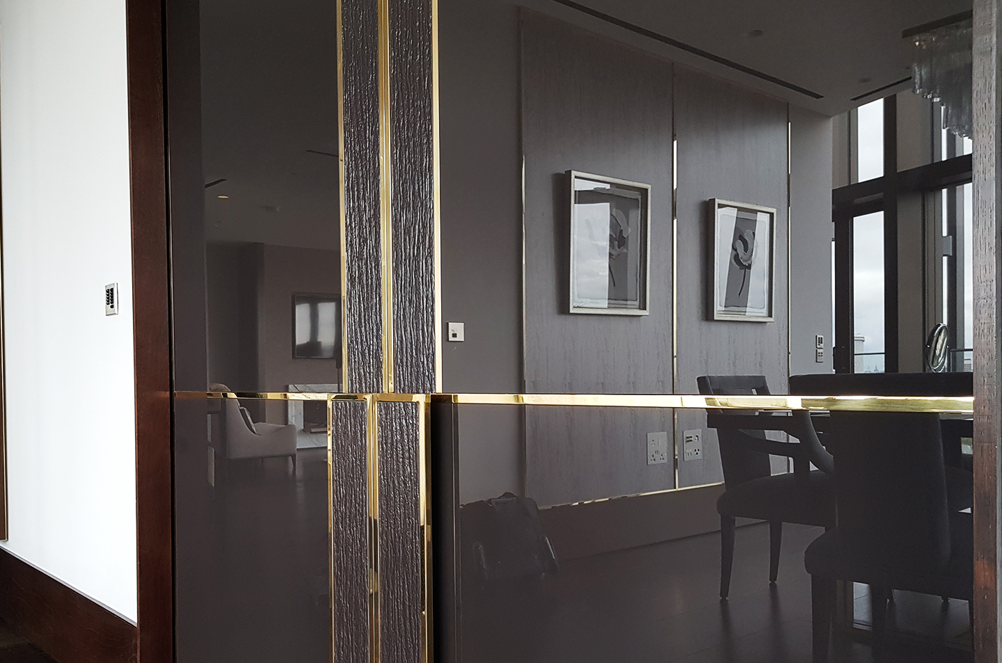 Mid-range view of polished brass grid detailing across dark panels