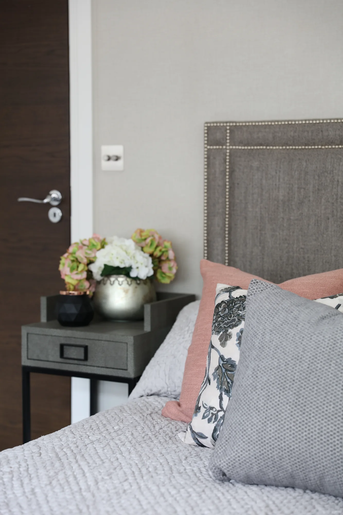Coordinating bedside table beside the upholstered headboard