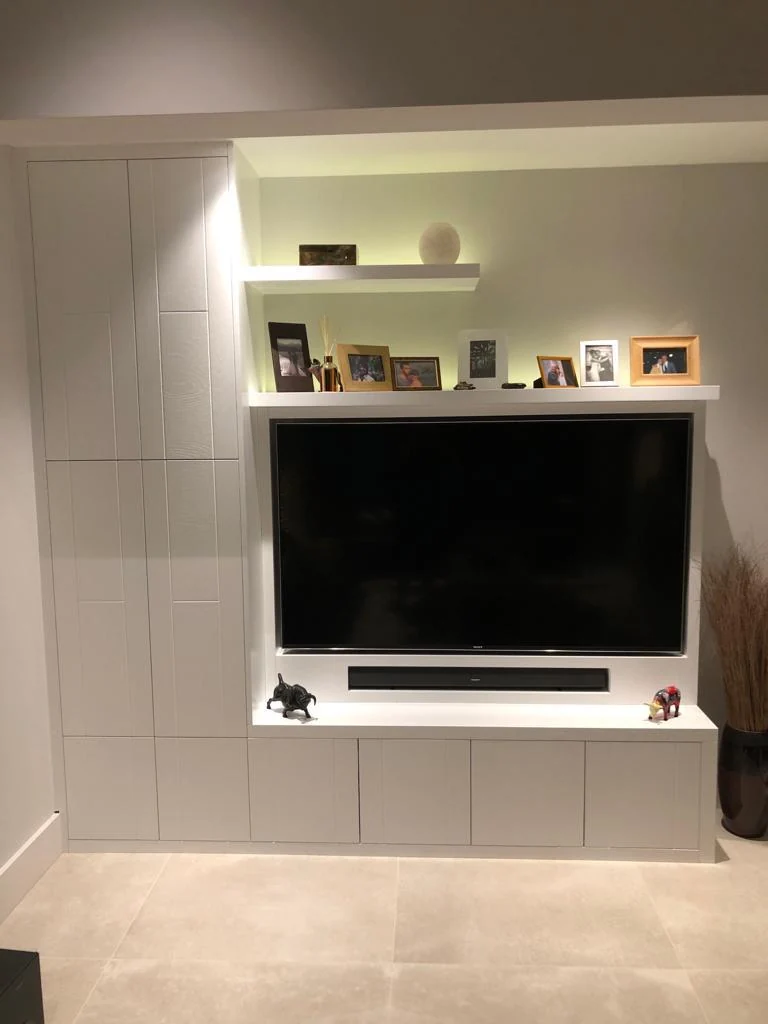 Front view of the pale media cabinet, tall cupboard and upper display shelves.
