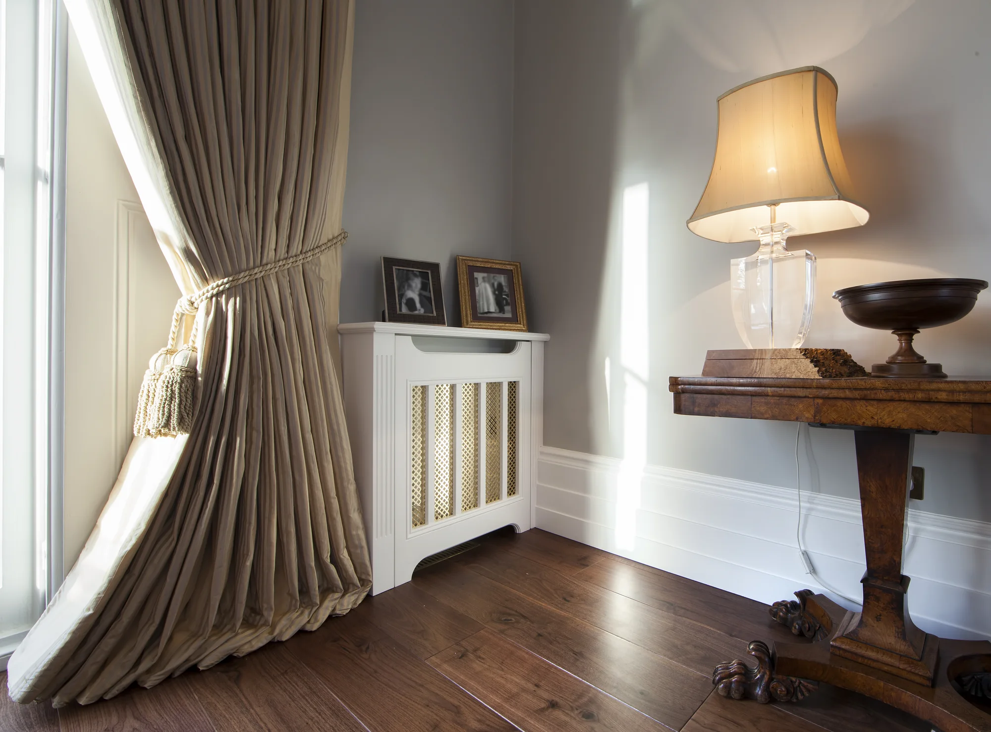 Angled view of the radiator-cover grille beside the curtains