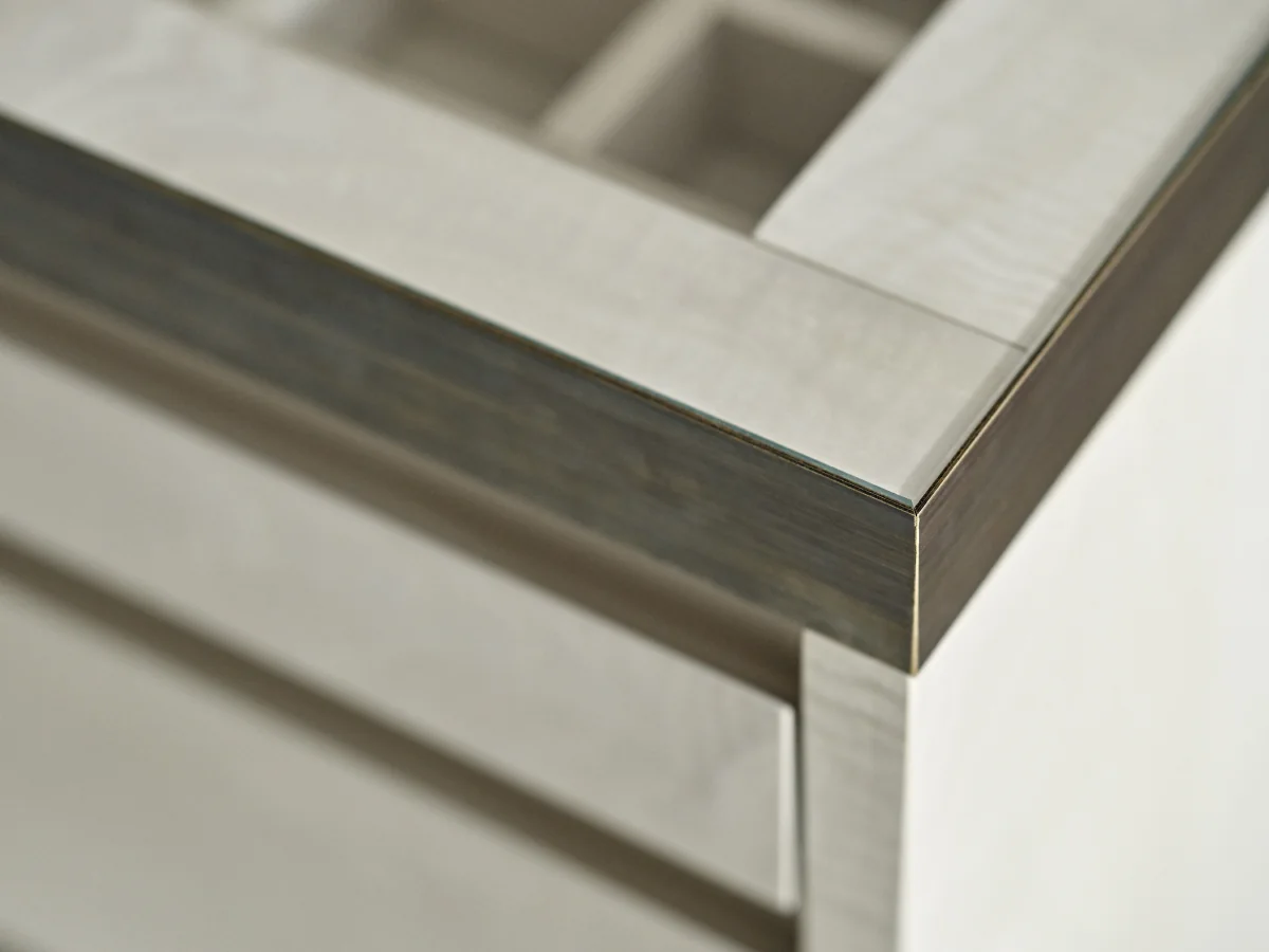 Glazed top, frame and pale drawer-front detail