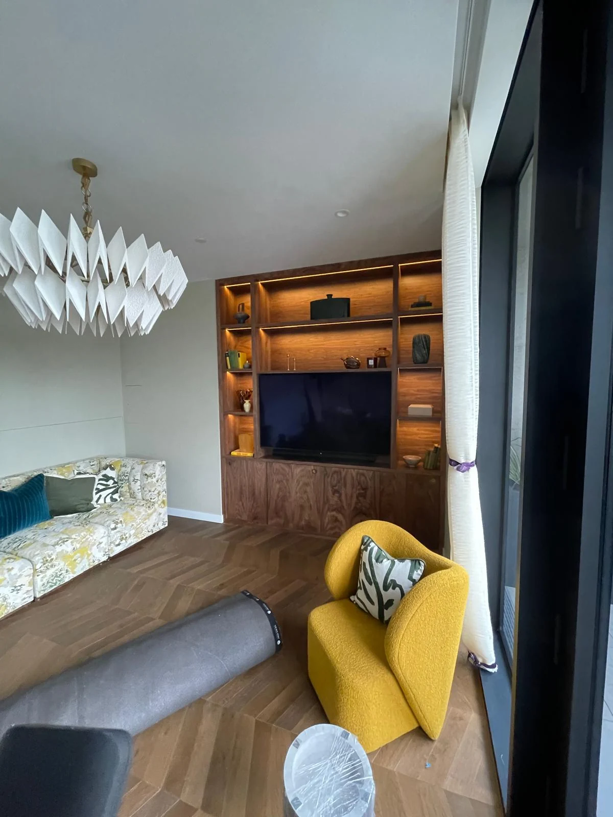 Room-context view of the timber media unit beyond a sofa.